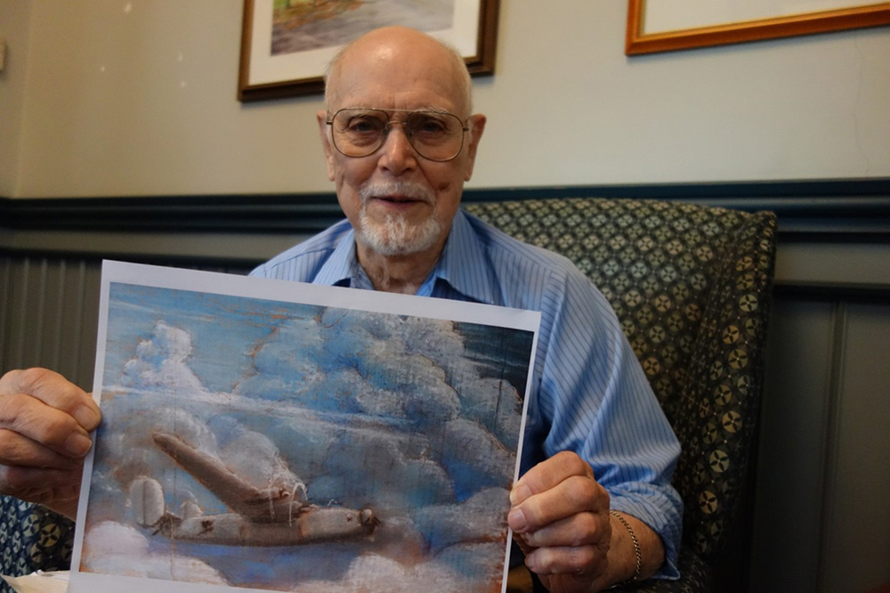 Tom Dahill with a picture of the B-24 he piloted in WW II